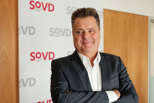 Jürgen Dusel vor einem Aufsteller mit SoVD-Logos. 