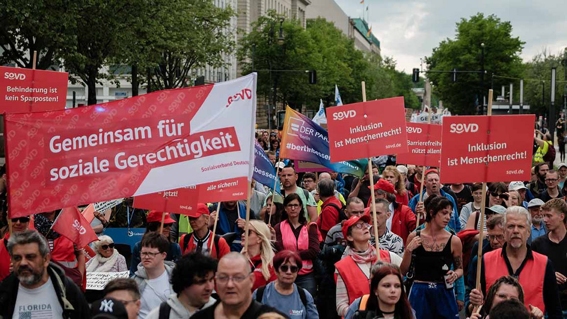 Demonstration in Berlin, viele Menschen halten Schilder des SoVD in die Höhe