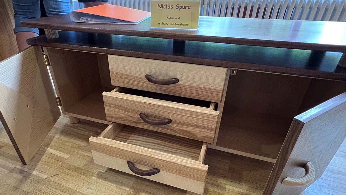 Möbelstück aus Holz mit Schubladen und offenen Türen. 